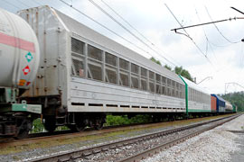 Кадр 5. Вагоны моделей 11-835 и 11-187 для перевозки автомобилей в составе товарного поезда; вдали виден вагон компании 